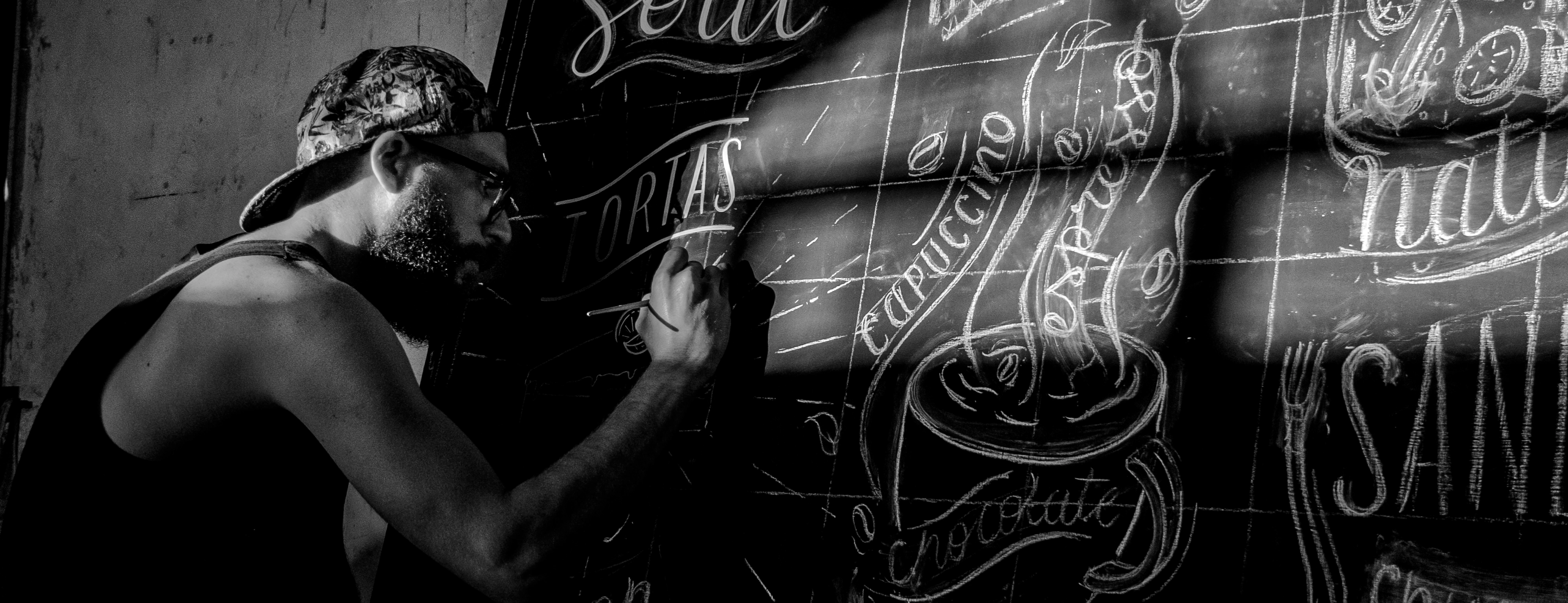Isa X-O dibujando a mano la pizarra de Café Soul.
